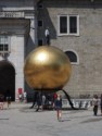 A sculpture of a man on top of a gold ball
